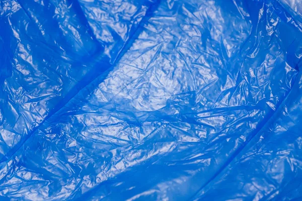 A blue plastic bag texture, macro, backgroundBlue plastic texture, macro, background, abstraction. Part of Shoe covers. Close up.