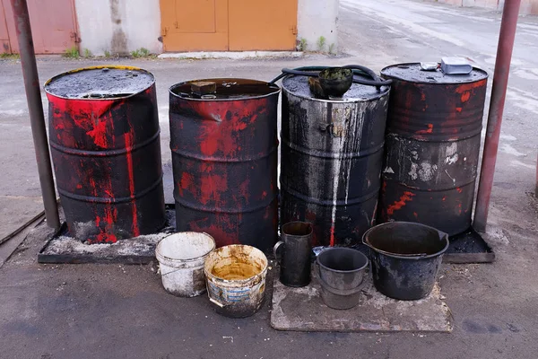 Dirty used colorful oil drums are modified to look like garbage cans in the engine room. Used engine oil in large barrels, buckets or containers. Environmental pollution, hazardous waste disposal