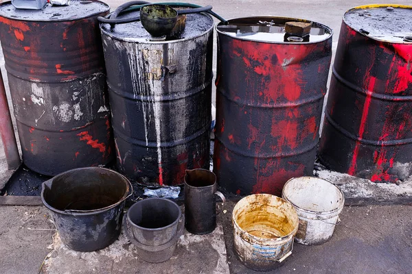 Dirty used colorful oil drums are modified to look like garbage cans in the engine room. Used engine oil in large barrels, buckets or containers. Environmental pollution, hazardous waste disposal