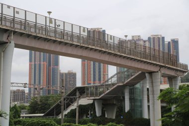 Şenzen, Çin 'de yüksek platforma sahip bir çelik yaya köprüsü bulunmaktadır. Yüksek binaların ve yemyeşil bitkilerin arka planında kimse yok.