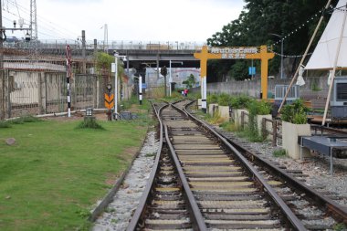 Demiryolu hattı şehrin içinden geçiyor, üzerinde eski sarı bir korkuluk var ve rayların her iki tarafında da yeşil çimenler var. Önünde pazar faaliyetleri için kurulmuş birkaç çadırlı küçük bir meydan var. Her platformun bir tarafında.