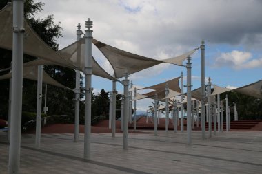 Sayısız beyaz direkleri ve tenteleri olan geniş bir alan. Tenteler tüm bölgeye yayılarak ziyaretçilere gölge ve barınak sağlıyor.