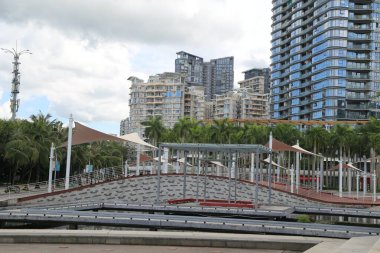 Meydanda modern binalar ve kanallar var. Her iki tarafında gri merdivenlerle çevrili birçok metal geçitli açık hava oyun alanı var. Kırmızı dikdörtgen panellerden oluşan eğimli bir çatı. 