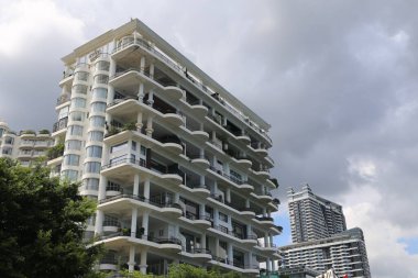 Shenzhen 'de balkonları ve modern mimarisi olan beyaz bir bina. Bir apartmanın en üst katında.