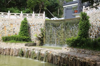 Sıcak kaynak havuzunun su duvarı beyaz çitli ve her iki tarafında yeşil bitkilerle küçük taşlardan yapılmıştır. Kaya dokusunun derinlik duygusu vardır ve önünde insanların oturabileceği ya da uzanabileceği boş bir alan vardır.