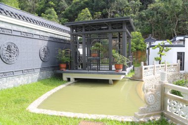 Çin usulü siyah taş oymalar, köşkler ve Çin usulü deniz yeşili bahçelerin bahçesinde küçük köprüler. Etrafı beyaz duvarlarla çevrili..