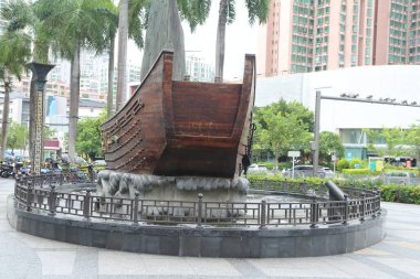 Büyük ahşap bir tekne çeşmenin ortasında. Tekne metal bir çitle çevrili.