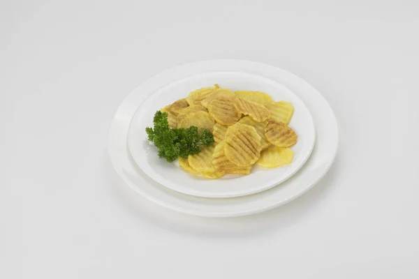 Beyaz arka plan üzerinde izole bir tabak içinde patates cipsi