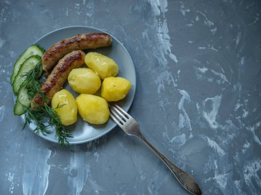 salatalık dereotu bir seramik tabak ızgara sosis dilimleri ile genç haşlanmış patates