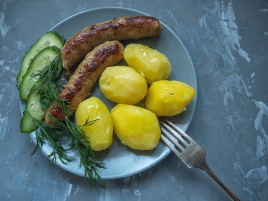 salatalık dereotu dal dereotu ızgara parçaları üzerinde sosis ile genç haşlanmış patates