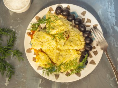 Yumurta ve baharat ile genç kabak dan omlet. Beton için gri bir arka plan üzerinde siyah zeytin, rezene şubeleri