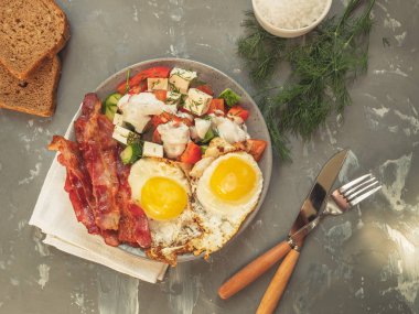 pastırma bir tabak sebze salatası ile yumurta kızarmış. Ekmek, dereotu, çatal bıçak takımı