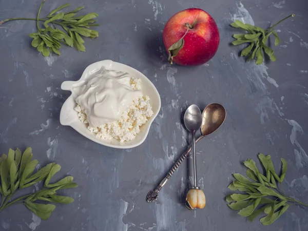 Ekşi krema, kırmızı elma, gri bir ahşap benekli yakın çekim ile taze peynir