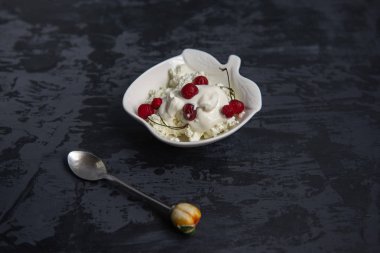 Rustik Kırmızı lor kiraz dekoratif Beyaz tabaklar çay kaşığı siyah bir zemin üzerine hafif kahvaltı