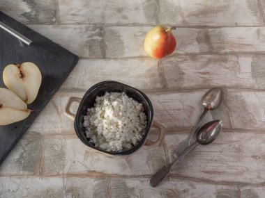 yararlı kahvaltı rustik süzme peynir, olgun armut, sofra, hafif ahşap masa üzerinde gümüş çatal bıçak takımı