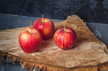 Üç Olgun kırmızı elma kadar yakın kesme Ahşap testere yalan
