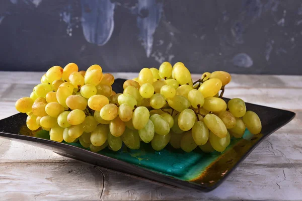 WhitSponge brush of white grapes on a ceramic plate close-upe grapes on a ceramic plate close up