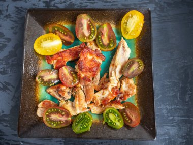 Besleyici kahvaltı kavrulmuş Türkiye, domates, baharat dekoratif seramik tabakta. Yakın çekim.