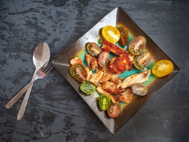 Besleyici kahvaltı kavrulmuş Türkiye, domates, baharat dekoratif seramik tabakta. Yakın çekim.