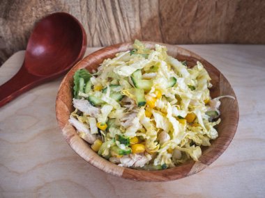 Beijing lahana, haşlanmış tavuk, konserve mısır, taze salatalık, yeşillik bir bambu tabak salata diyet. Yakın çekim. Büyük kızlık kaşık.