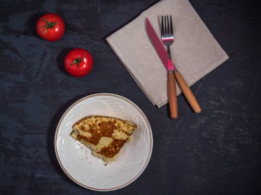 Omlet ve domates, çatal bıçak takımı karanlık bir arka plan üzerinde hafif kahvaltı