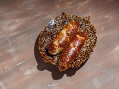 Dekoratif tabak, bir cam sürahi, çatal bıçak takımı, pamuk peçete kahverengi zemin üzerine şurubu baget