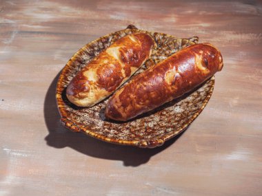 Dekoratif tabak, bir cam sürahi, çatal bıçak takımı, pamuk peçete kahverengi zemin üzerine şurubu baget