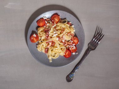 Beyaz peynir ve domates bir seramik tabak spagetti serpilir.