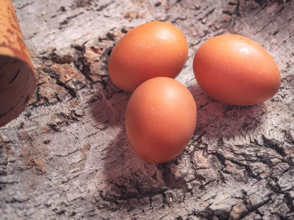 Üç büyük kahverengi tavuk yumurta kuru kabuk üzerinde yalan. Atış yakın çekim.