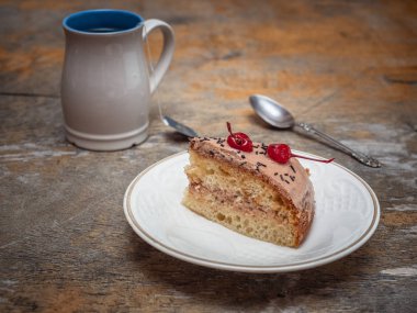 Tatlı yemek pasta ve çay ile bir tatlı kaşığı yakındaki yatıyor.