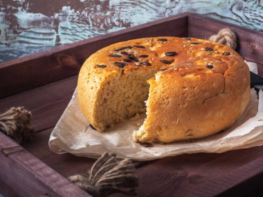 Ev yapımı ekmek yuvarlak şekilli bir kesim yanında bir ahşap rustik tepsi içinde tohum ile bir mutfak bıçağı olduğunu