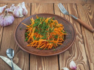 Kahverengi seramik plaka içinde dereotu ve bitkisel yağ ile taze havuç salatası.