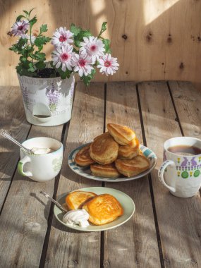 Tabak üzerinde taze pişmiş krep, eski bir tahta masada bir dekoratif çiçek çiçeklenme pembe krizantem.