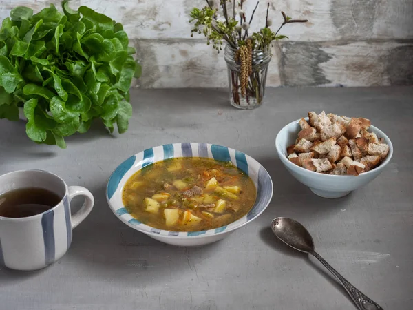 Обед гороховый суп с крекерами, куст зеленого салата на заднем плане — стоковое фото
