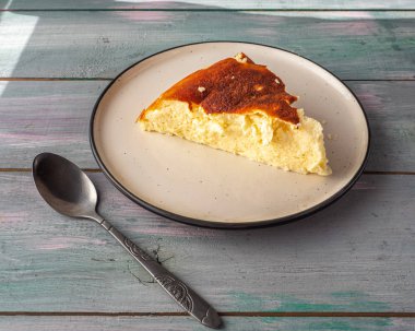 Bir çay kaşığı ile yuvarlak bir seramik kase üzerinde Süzme peynir güveç