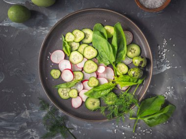 Büyük yuvarlak gri plaka otlar ve yumurta ile sebze plakası.