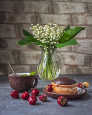 Kek ve çilek, bir cam sürahi vadinin zambak bir buket ile lezzetli atıştırmalık