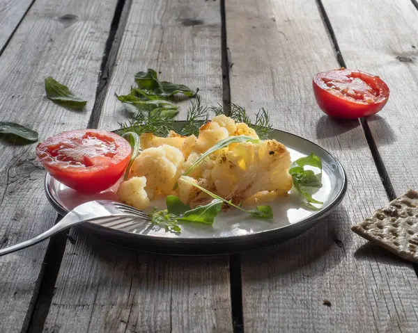 Almuerzo ligero de coliflor asada y mitades de tomate rojo — Foto de Stock