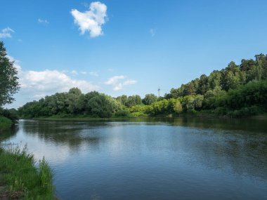 Güzel yaz peige. Mavi gökyüzü parlak güneşli bir günde derin bir nehre yansır. Gökyüzündeki bulut.