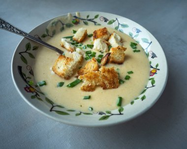 Derin bir kapta krema ve tost ekmeği parçaları ile taze yapılmış peynir krema çorbası