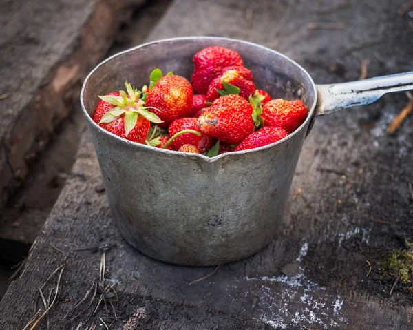 Un cucharón de fresas maduras del jardín rústico sobre tablas viejas —  Fotos de Stock