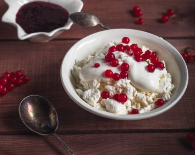 Yakın mesafeden çekilen ekşi krem ve kırmızı frenk üzümü çilek ile süzme peynir hafif kahvaltı