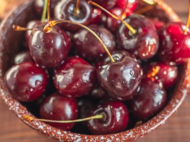 Açık bir tepsi üzerinde derin bir seramik kahverengi kase Olgun büyük tatlı kiraz, yakın mesafeden çekim, üst görünüm