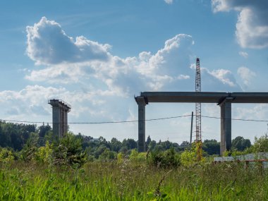 Bir yaz gününde, yapım aşamasında bir köprü ile bulutlu bir gökyüzüne karşı Manzara