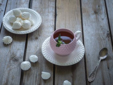 Sabah çayı. Seramik dekoratif vazo. Beze kurabiye, ahşap bir masa üzerinde kompozisyon