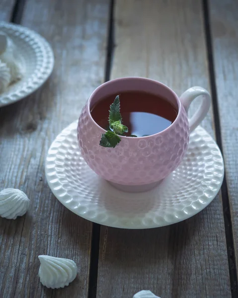 Zelený čaj v růžovém keramickém džbánu na rustikálním nepomalovaným stole — Stock fotografie