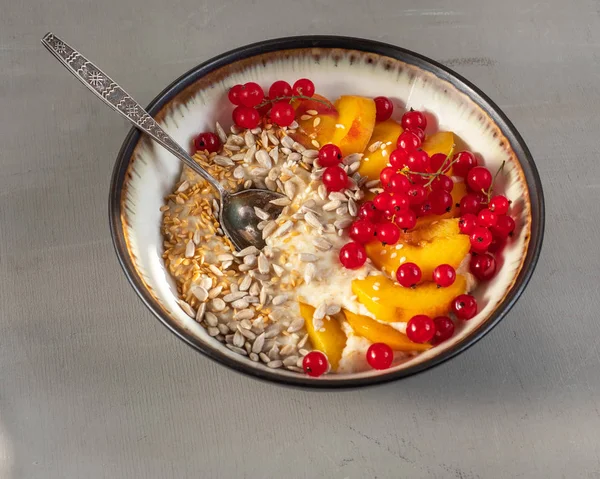 Здорова фітнес Сніданок з вівсянкою з ягодами, фруктами і зернами в глибокій тарілці, ложкою — стокове фото