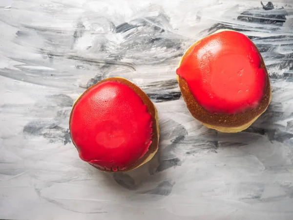 Açık tabakta kırmızı jöleli çilekli iki çörek, yakın çekim üst manzara. Siyah beyaz arkaplan