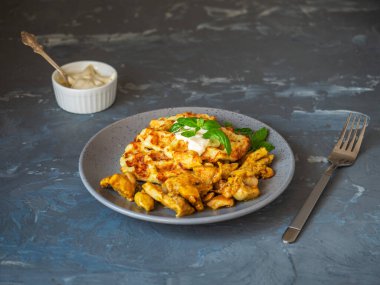 Gri tabakta sos ve fesleğenli sebze kabaklı waffle. Gri arkaplan ve masa çatalı.