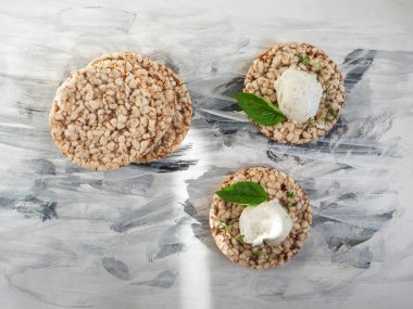 Süzme peynirli sağlıklı sandviçler ve buğday kepekli otlar siyah beyaz kağıt peçete manzaralı.